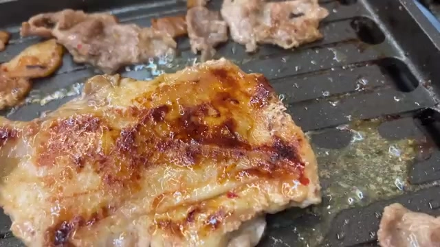 方形烤盤上的肉片煎烤得焦香油亮，是這間店的招牌現切烤肉