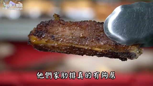 夾起的肋排焦香油亮,邊緣帶著炭烤焦脆的痕跡