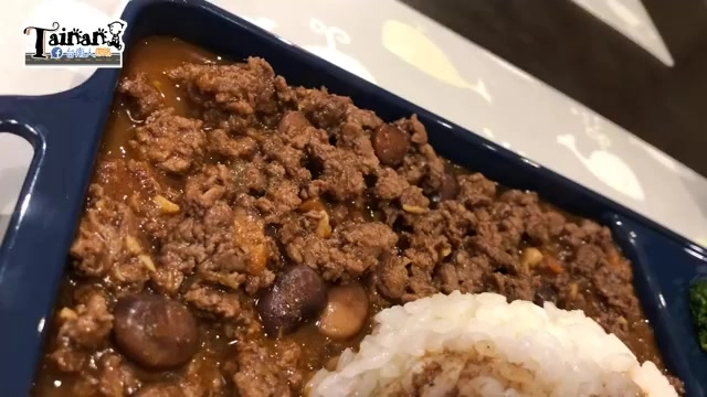 深藍色餐盤盛著墨西哥肉醬，可見絞肉與黑豆混合的醬料，旁邊搭配白飯