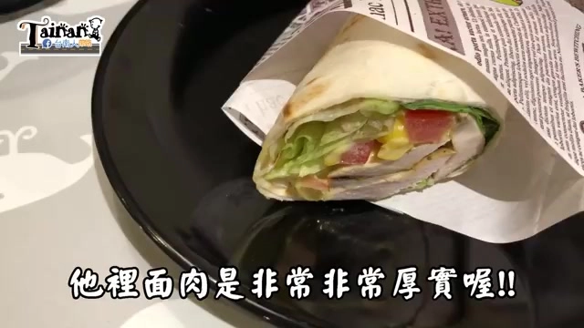 黑色圓盤上放著切半的墨西哥捲餅，內餡可見生菜、番茄與厚實雞肉，字幕寫著「他裡面肉是非常非常厚實喔!!」