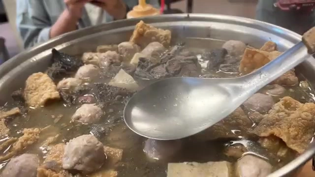 薑母雞湯鍋內料多豐盛，貢丸、豆皮、菇類與雞肉塊燉煮在甘甜湯頭中