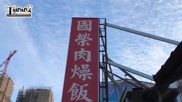 店家招牌高掛,紅底白字寫著「國榮肉燥飯」,藍天背景襯托