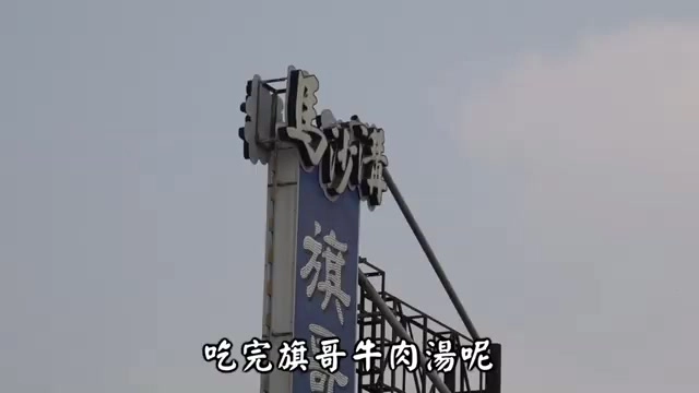 藍白招牌立於高處,寫著「旗哥牛肉湯」字樣