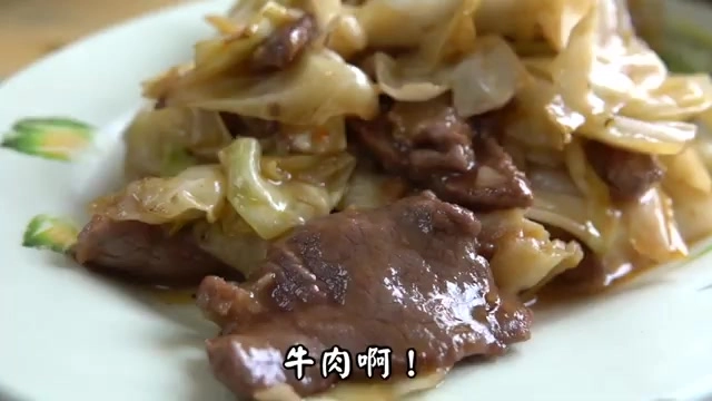 白色瓷盤盛著炒高麗菜與牛肉片,醬色油亮,高麗菜份量豐富