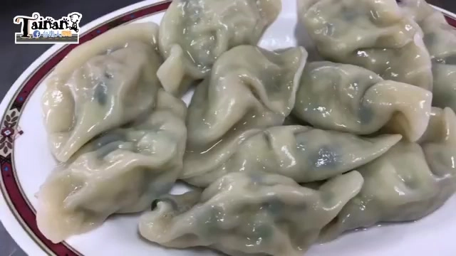 白色瓷盤盛著多顆水煮水餃，餃皮微透可見內餡的翠綠韭菜色澤