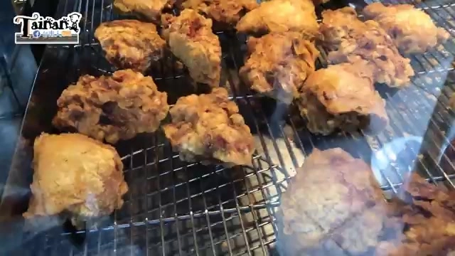 烤架上擺放著多塊炸得金黃酥脆的雞肉,色澤深褐油亮