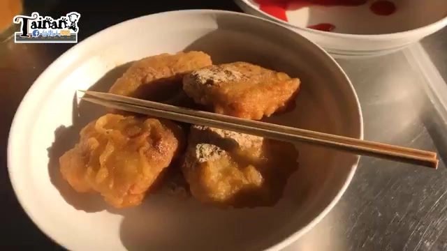 白色瓷盤盛著炸熱狗與炸雞塊，外皮呈現金黃酥脆色澤，旁邊放著筷子