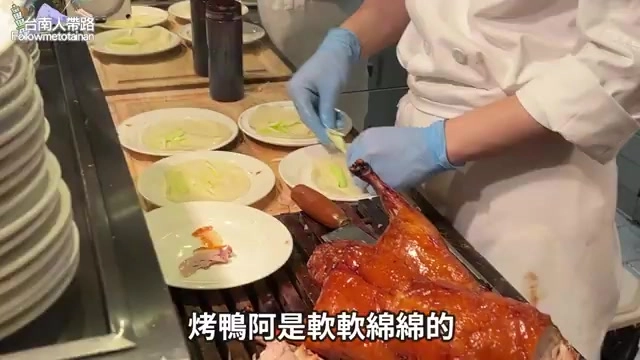廚師現場片切荔枝木烤鴨，鴨皮油亮酥脆搭配夾餅與蔥段