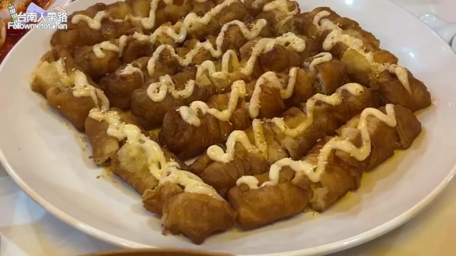 百花油條淋上美乃滋整齊排列滿盤，內餡鮮蝦漿包裹在酥炸油條中