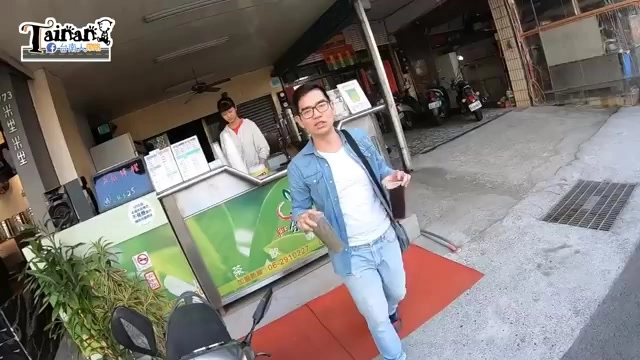 店家攤位前，老闆正在製作飲料，攤位上擺著菜單看板與收銀機，旁邊停著機車