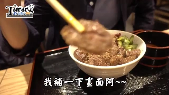黑色托盤上的牛丼特寫，米飯上鋪滿烤牛肉片與青蔥點綴，筷子正夾起一片肉