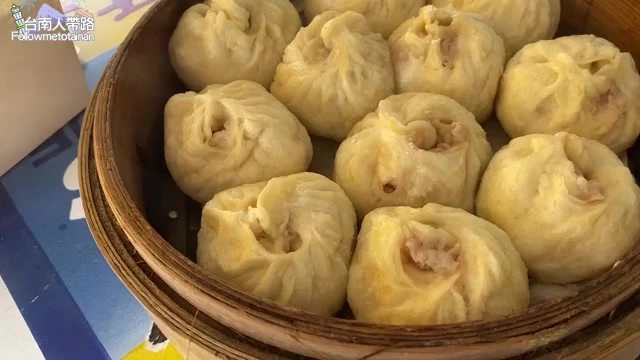 竹製蒸籠裡整齊排列著多顆飽滿的白色包子