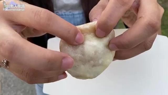 雙手捧著剛出爐的白色蒸包,表面還冒著蒸氣