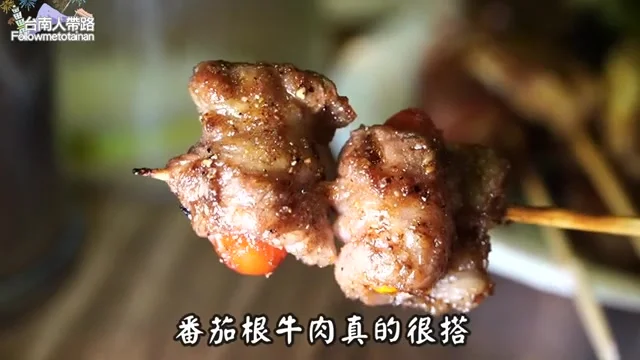 阿波夾起番茄牛肉捲，展示烤肉醬色澤