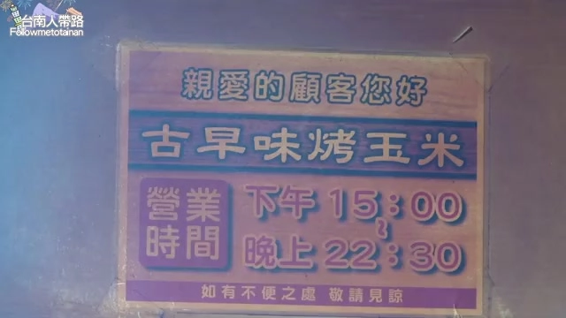 木製看板寫著「親愛的顧客您好,古早味烤玉米」,標示營業時間下午15:00至晚上22:30