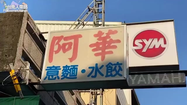 阿華意麵水餃店的招牌高掛在店門口，紅字白底寫著意麵水餃