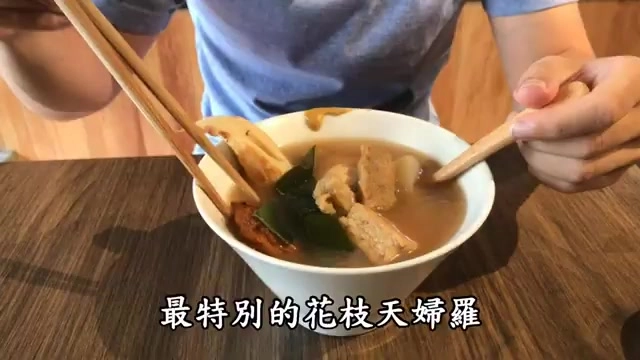 白色湯碗盛著關東煮，可見花枝、蘿蔔與豆腐等配料浸在清湯中，筷子與湯匙正夾取食材，字幕寫著「最特別的花枝天婦羅」