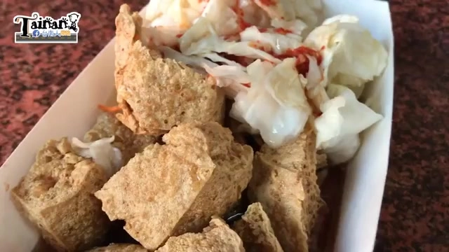 白色紙盒中盛著切塊酥炸豆腐，搭配泡菜與辣椒點綴