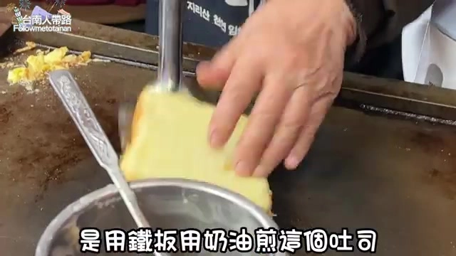 老闆用鐵板奶油煎製吐司，吐司壓得扎實準備煎至外皮酥脆