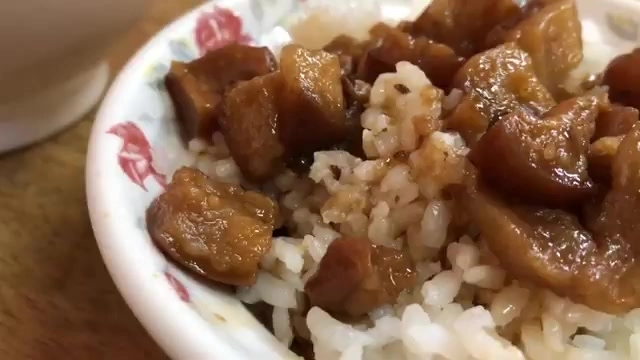 白瓷碗盛著肉燥飯，深色滷肉塊鋪滿米飯，油亮誘人