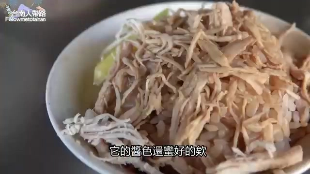 白飯上鋪滿撕成細絲的雞肉,醬色深厚均勻裹附在米粒與雞絲上