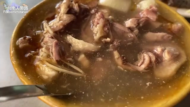 黃色瓷碗中盛著當歸鴨湯,湯色清澈微黃,鴨肉塊與骨頭清晰可見