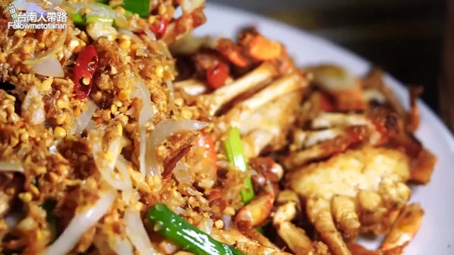 盤中盛著避風塘炒蟹,裹著金黃酥脆的蒜蓉與辣椒碎料,色澤誘人