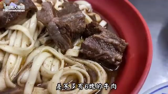 紅色碗中盛著寬版麵條與大塊燉煮牛肉,湯色濃郁,標示「差不多有6塊的牛肉」