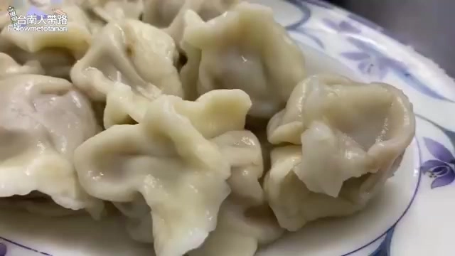白色瓷盤中盛著多顆水餃,皮薄透亮,摺紋分明