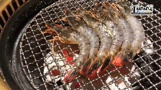 黑色鐵網烤架上並排著多隻新鮮草蝦,蝦身泛著烤炙的光澤