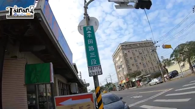 路口的路牌上寫著「本田路三段」，搭配周邊建築物與街景
