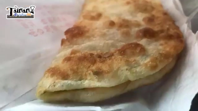 剖開的烙餅特寫，表皮呈現金黃焦香色澤，帶著自然的烘烤斑紋