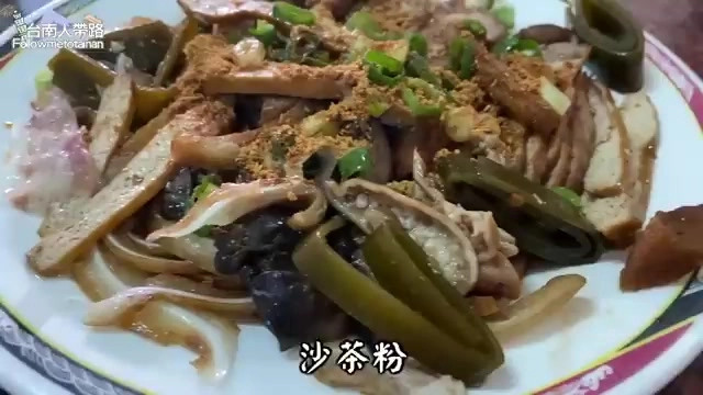 白色盤中盛著多樣滷味拼盤，撒上沙茶粉、蔥花與辣椒點綴，色澤深褐