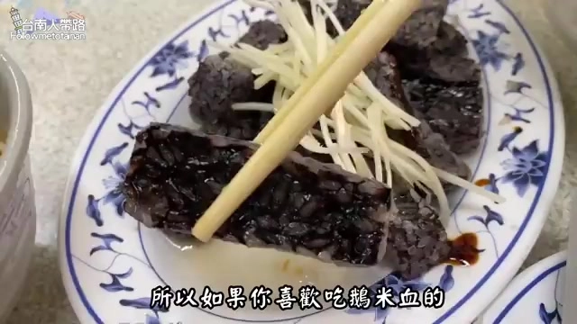 黑色米血糕切片擺盤,搭配新鮮白蘿蔔絲與醬汁點綴
