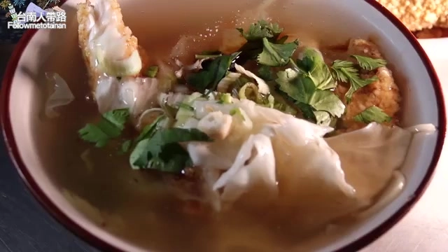 白瓷碗中盛著土魠魚羹,湯料豐富,撒上香菜與蔥花,色澤清爽