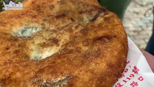 特寫蔥肉餅表面煎得金黃酥脆,中間露出綠色蔥餡,撒著胡椒粉