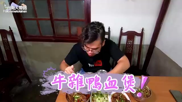 黑色圍裙男性主持人低頭大口享用桌上擺著的牛雜鴨血煲與其他小菜
